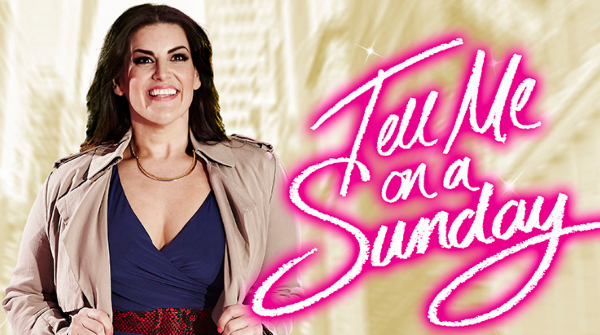 A woman is stood in front of a pale tan city scape. She is wearing a tan mac coat and smiling out, looking ahead. To the right is the title in neon pink: 'Tell Me On a Sunday'.